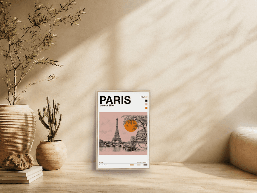 Paris Atlas print of the Eiffel Tower from the Seine, leaning against a sunlit wall beside an olive tree.
