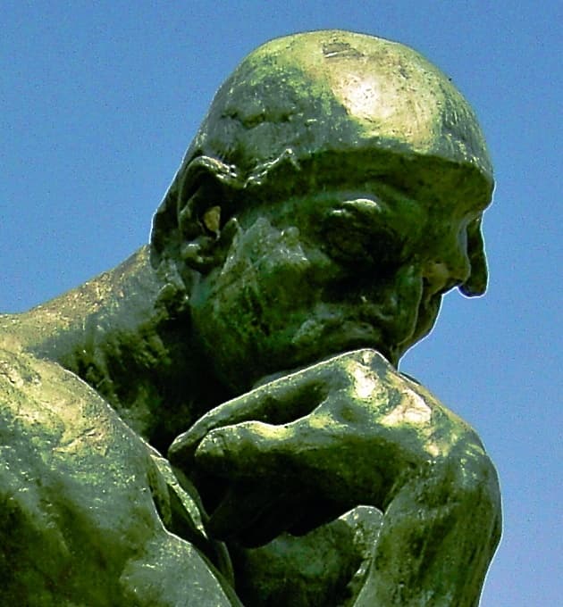 Detail: The Thinker's face and fist, brow contracted, mouth compressed, back of the right fist pressed under the jaw