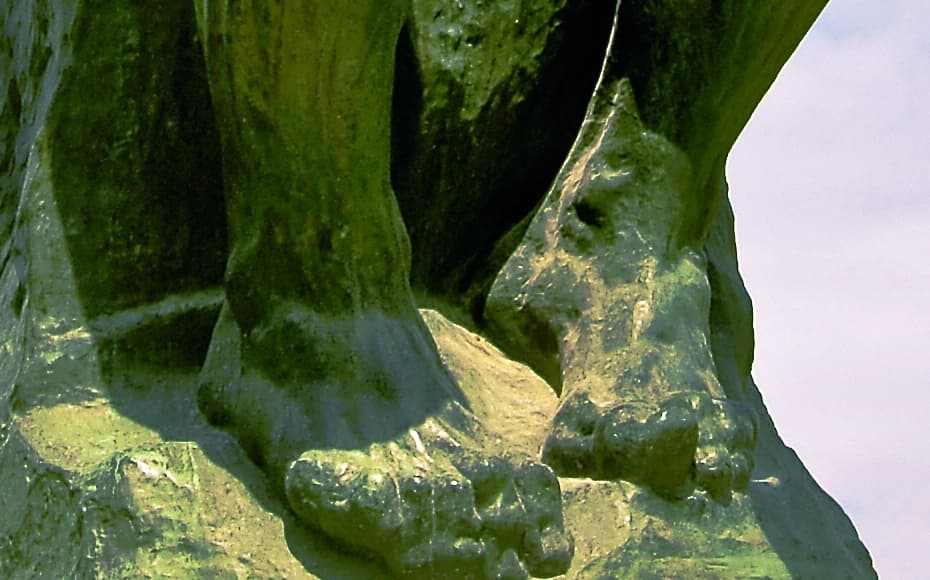 Detail: The Thinker's two feet on the rock beneath him, the right foot planted flat and the left pulled back on its toes, both gripping unevenly