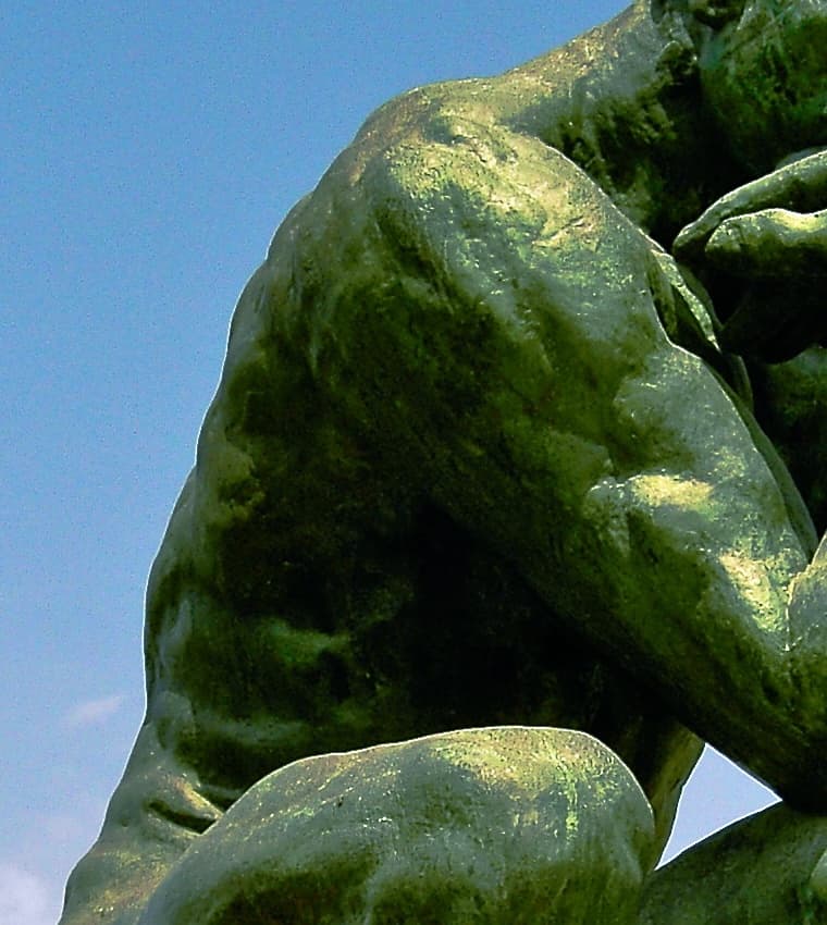 Detail: The Thinker's shoulder and upper back at close range, showing the pitted marked surface of the bronze where Rodin's fingerprints in the original clay were preserved through casting