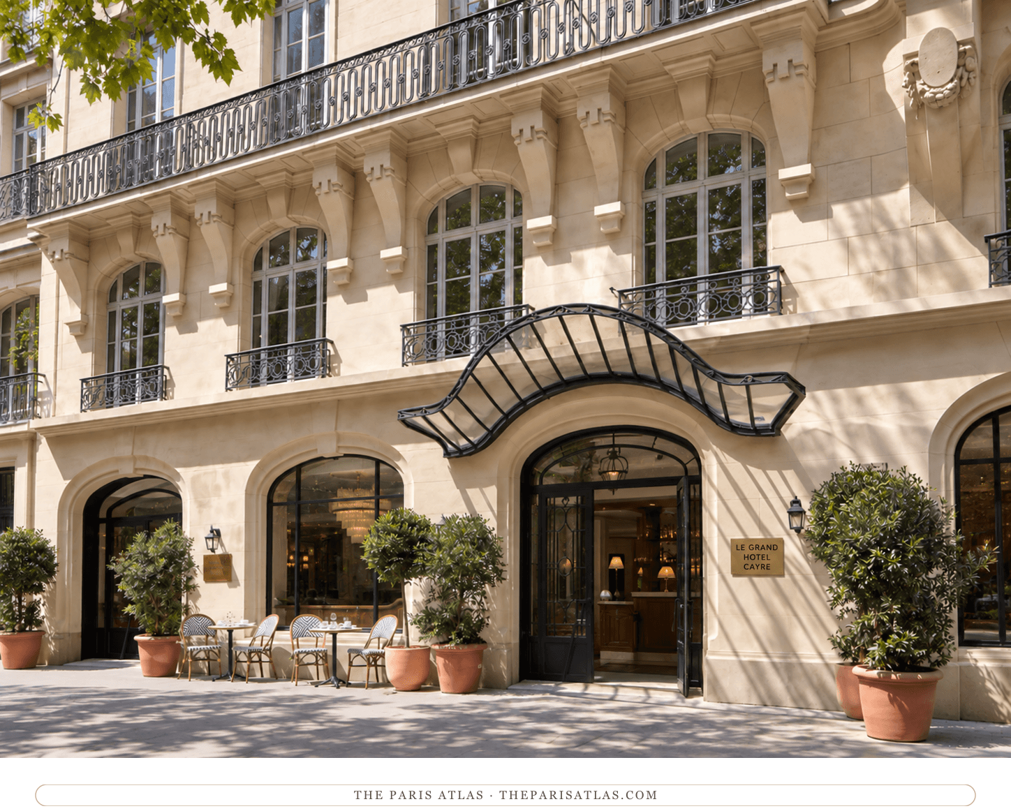 Photorealistic illustration of Le Grand Hôtel Cayré, with a curved glass entrance canopy, pale stone balconies, potted shrubs and pavement café tables.