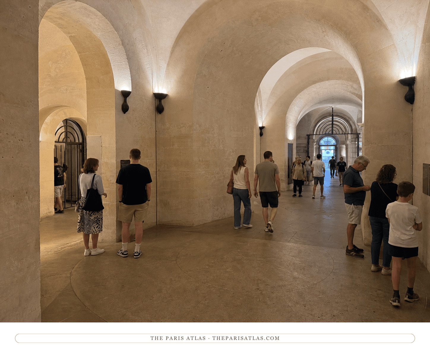 Present-day visitors walking through the limestone vaulted corridors of the Panthéon crypt