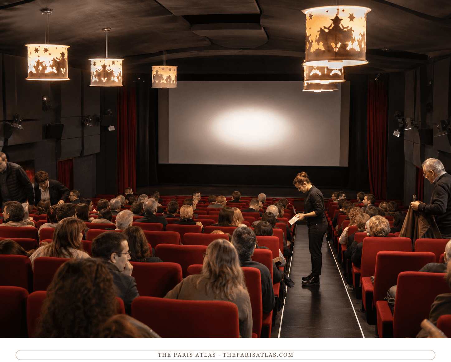 Audience settling into Studio 28's red auditorium beneath Jean Cocteau chandeliers