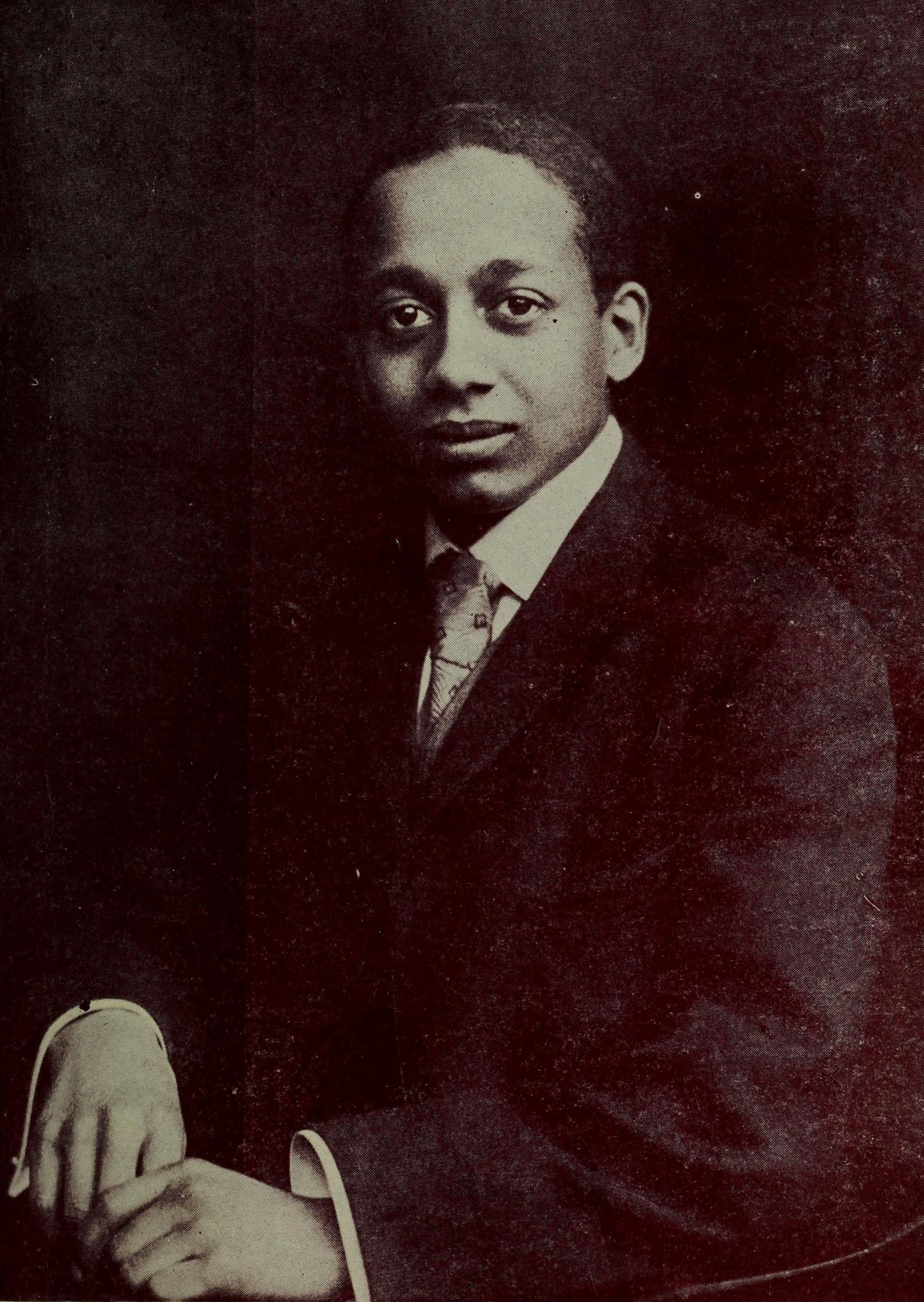 Alain LeRoy Locke as a young man, formal portrait photograph, wearing a suit and tie