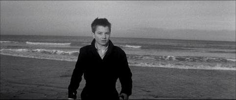 Freeze-frame of young Antoine Doinel on a grey beach, the sea behind him, looking directly into the camera