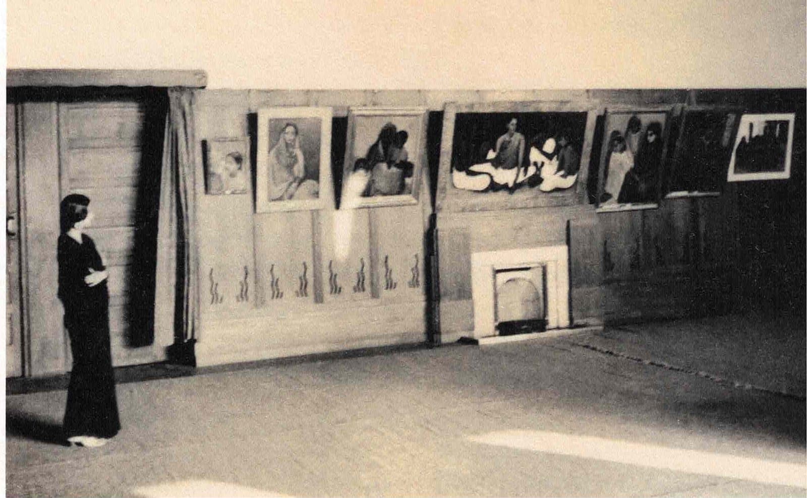 Amrita Sher-Gil standing among her paintings at her Lahore exhibition in 1937