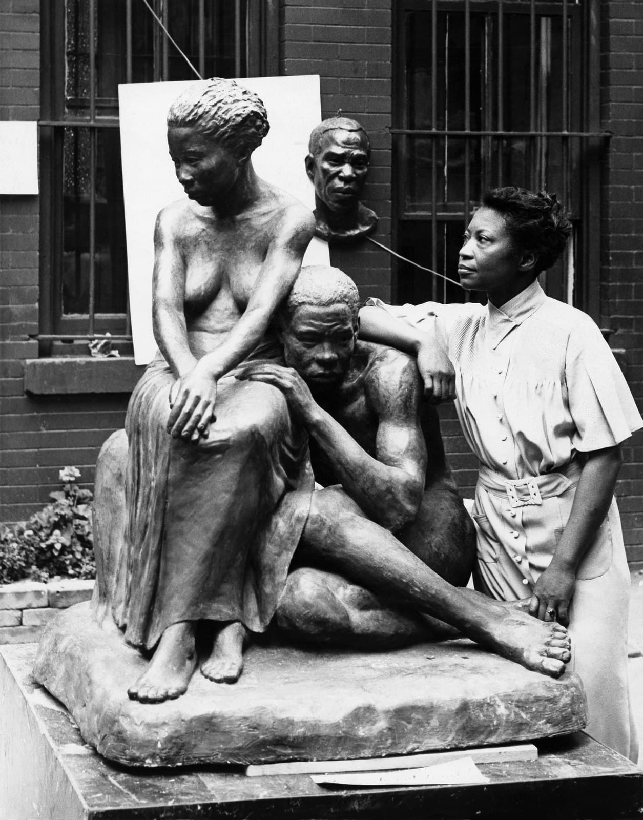 Augusta Savage seated beside her sculpture Realization in Harlem around 1938