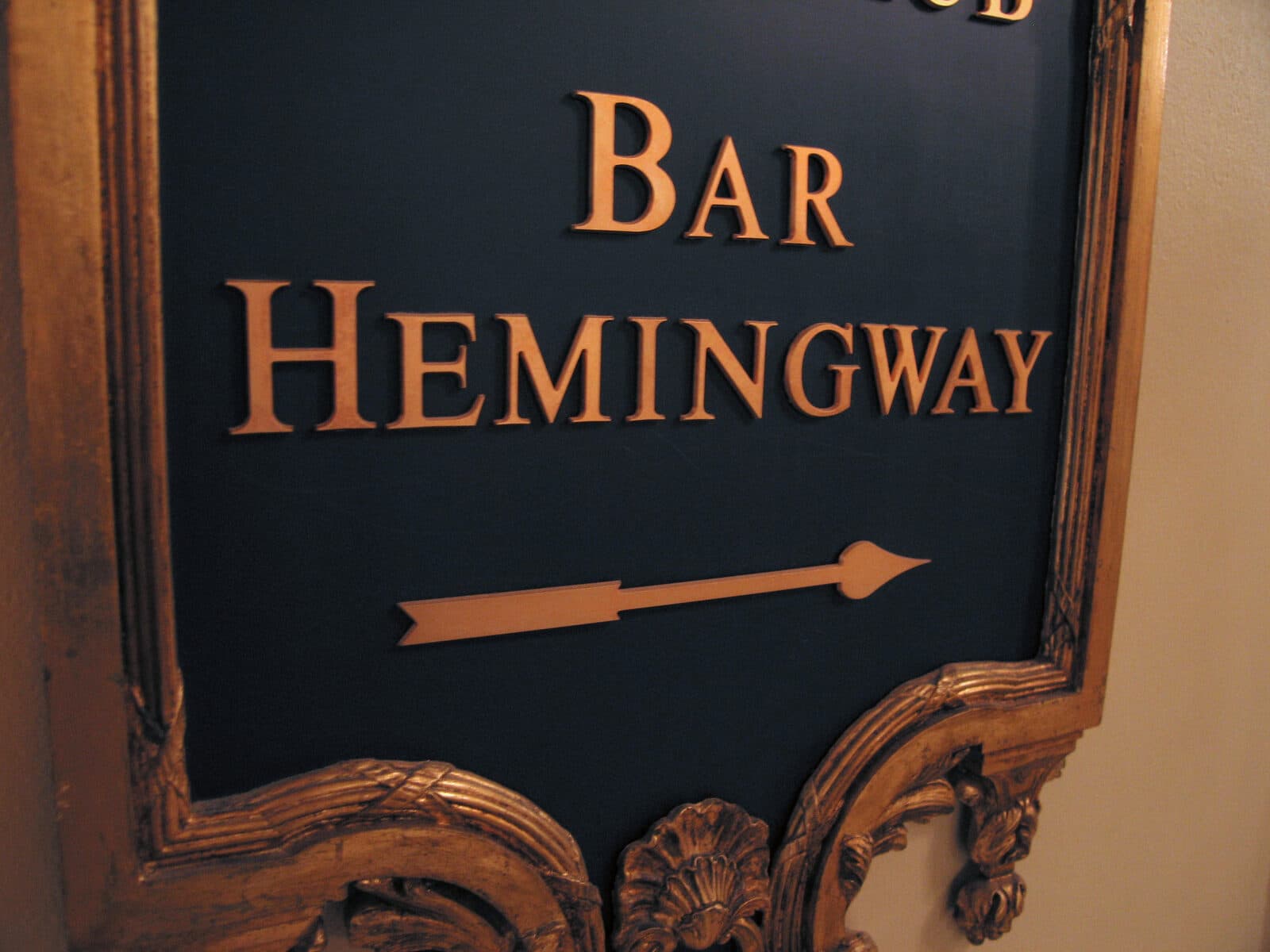 Gilded corridor sign of Bar Hemingway at the Hôtel Ritz, with an arrow pointing the way