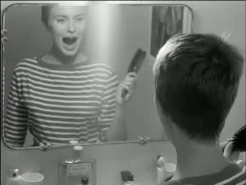 Jean Seberg laughing in a bathroom mirror in Room 12 of the Hôtel de Suède, from Breathless