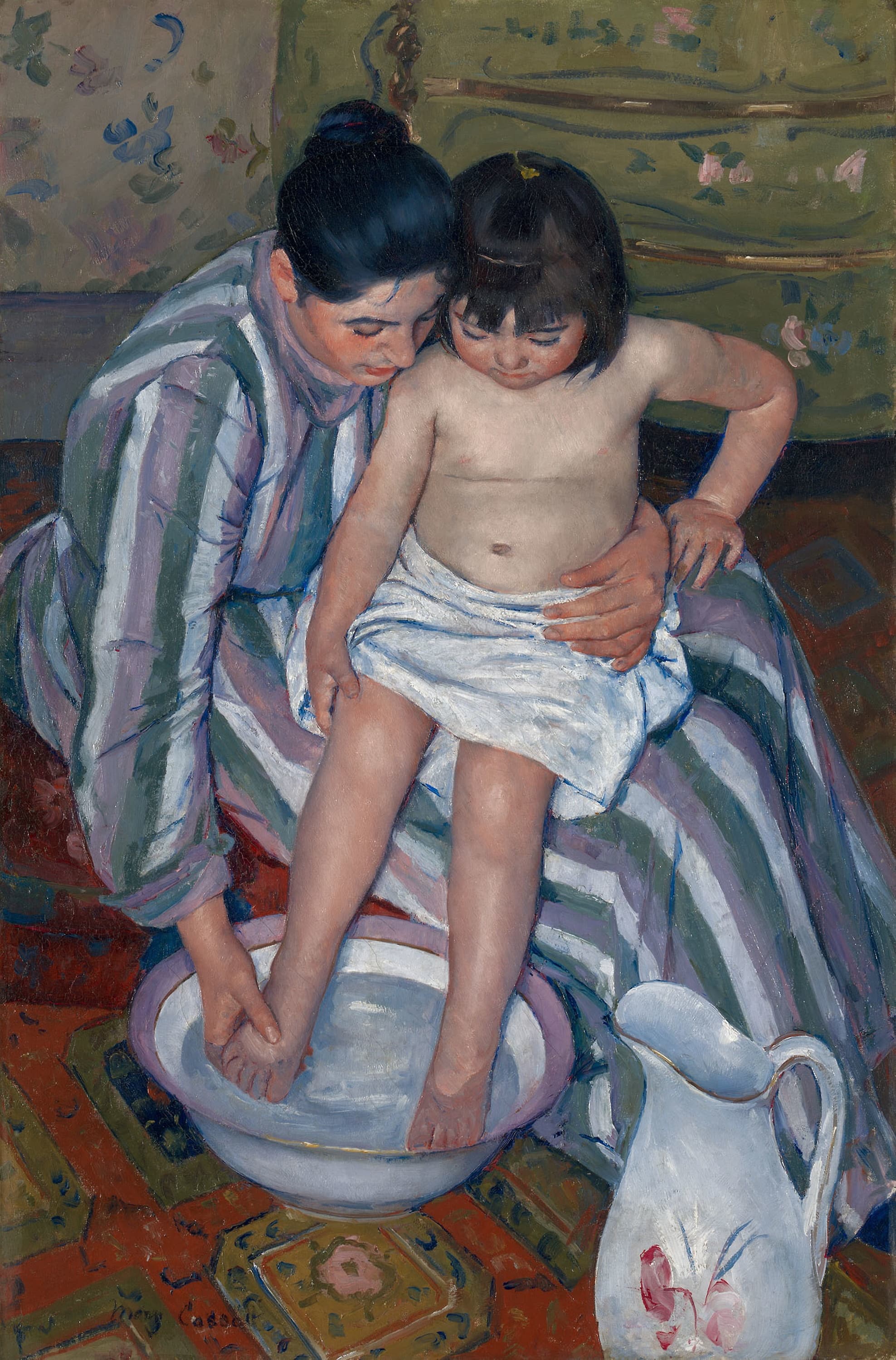 Seen from above, a woman in a striped dress holds a child on her lap and washes the child's foot in a flowered basin, the patterned carpet tilting up behind them