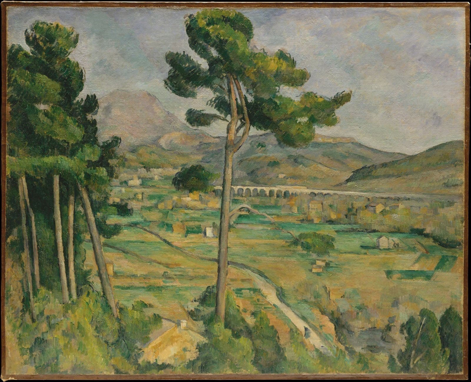 Cézanne's Mont Sainte-Victoire: the limestone mountain rises beyond a plain of fields, trees, and a distant viaduct, framed by a pine