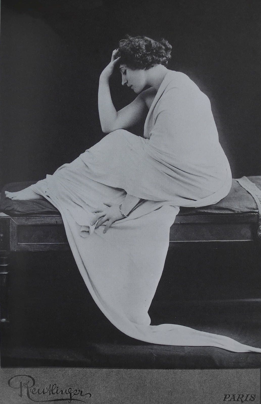 Colette seated in profile in a long pale drape for a 1909 Reutlinger studio photograph