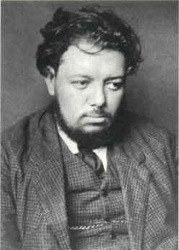 Diego Rivera standing in a dark suit and broad-brimmed hat in a 1910 studio portrait