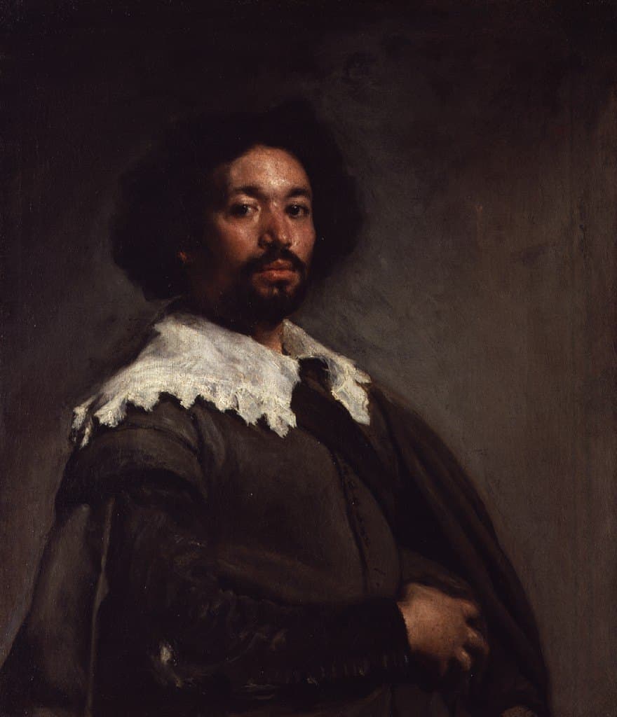 A half-length portrait of a man of African descent against a plain gray-brown background. He has dark curly hair and a short beard, and looks out steadily over his right shoulder. He wears a gray-green doublet with a wide white lace collar, a dark cloak draped over his shoulder, and his right hand rests at his waist.