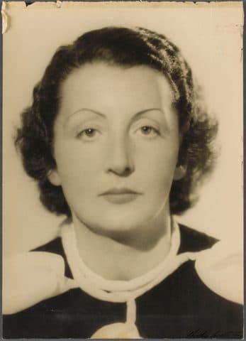 Formal studio head portrait of Domenica Walter, dark-haired with a white collar over a dark dress.