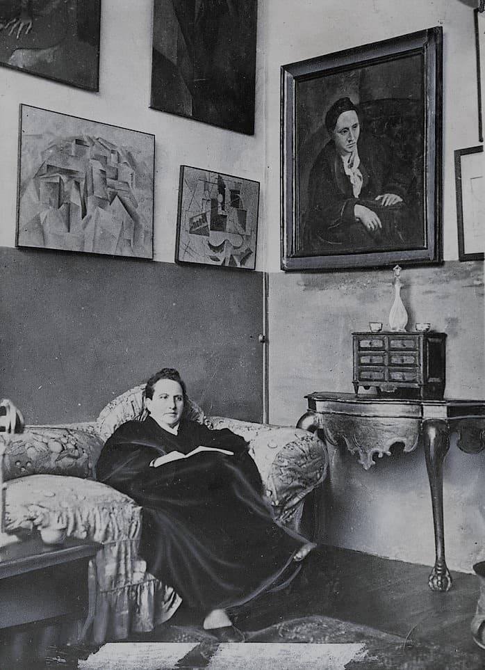 Gertrude Stein sitting on a sofa in her Paris studio, 1930