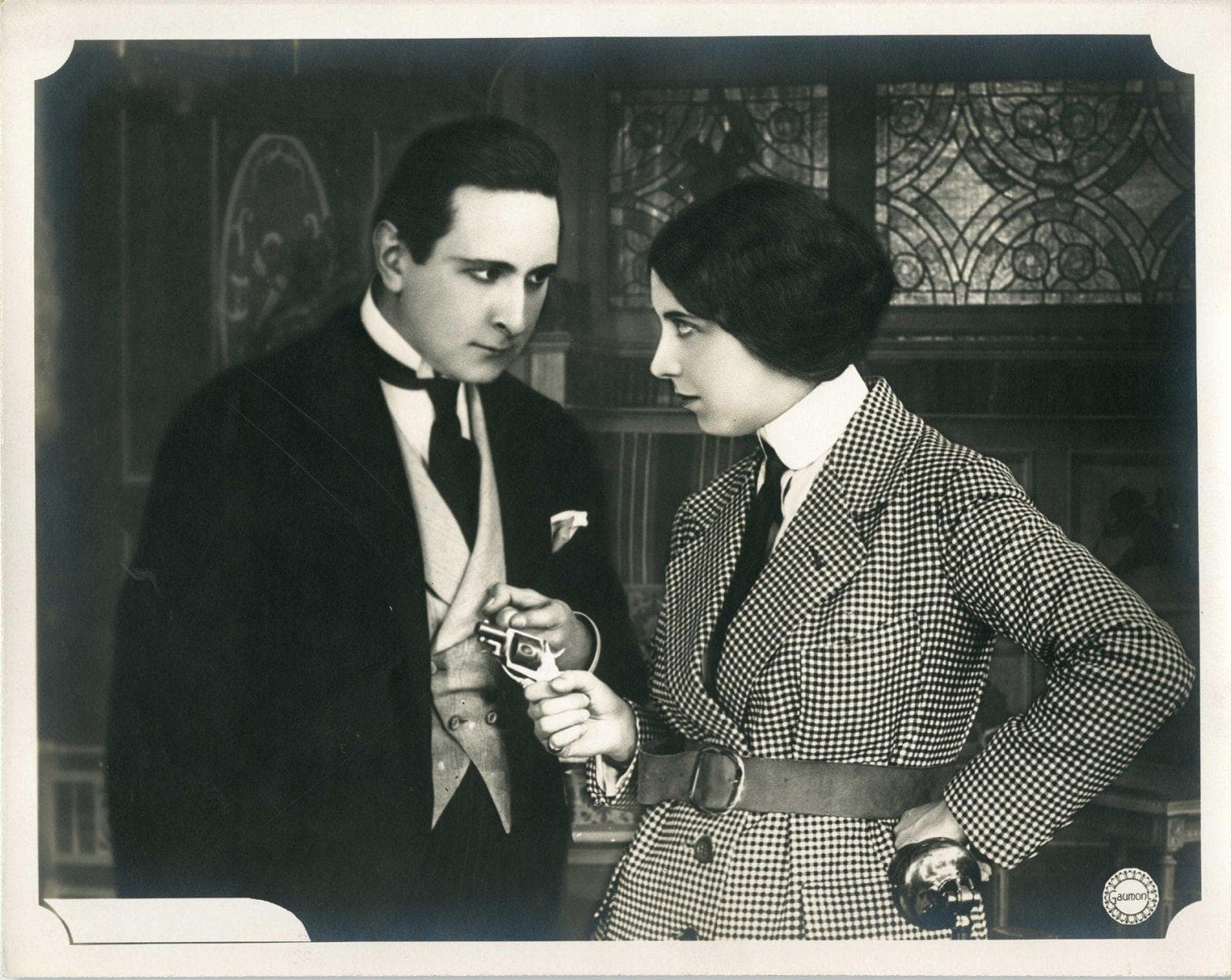 Irma Vep levelling a revolver in a still from Les Vampires, 1916