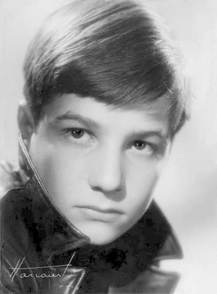 Studio Harcourt black-and-white portrait of the teenage Jean-Pierre Léaud in a dark leather jacket with the collar turned up, hair falling over his forehead, gazing gravely past the camera