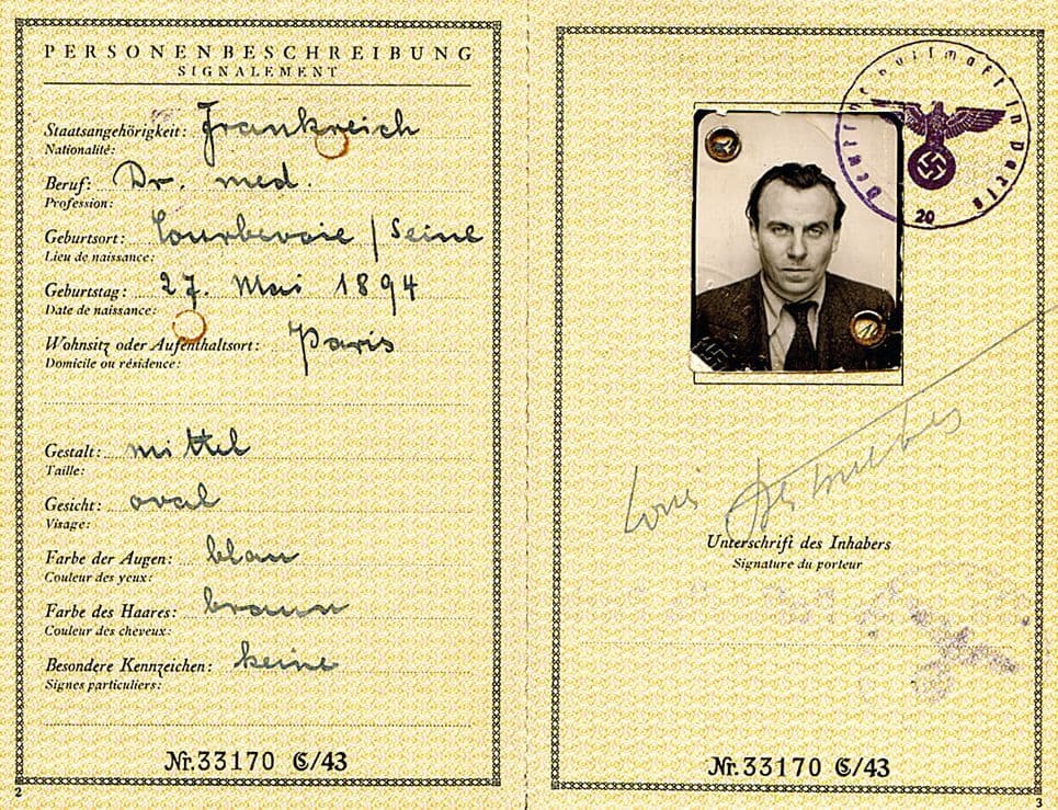 The identity page of Louis-Ferdinand Céline's German Fremdenpass — a foreign passport used during the war years — with a small black-and-white photograph of his head and shoulders, his name typed as Louis Ferdinand Auguste Destouches, his stamp and signature, and the eagle-and-swastika embossed cover partly visible.