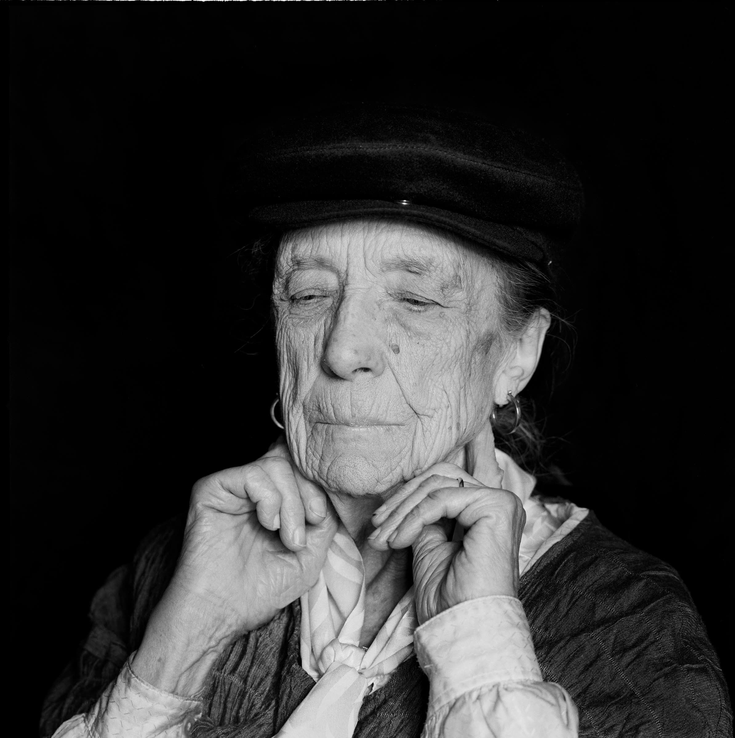 Louise Bourgeois at eighty-four, in a dark fur-collared coat, looking directly into the camera with her chin slightly raised