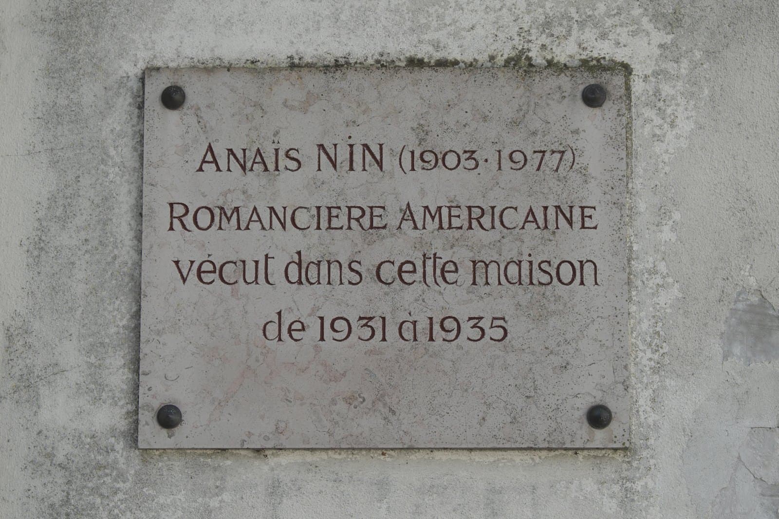 Stone plaque on a wall in Louveciennes reading Anaïs Nin 1903-1977, romancière américaine, vécut dans cette maison de 1931 à 1935