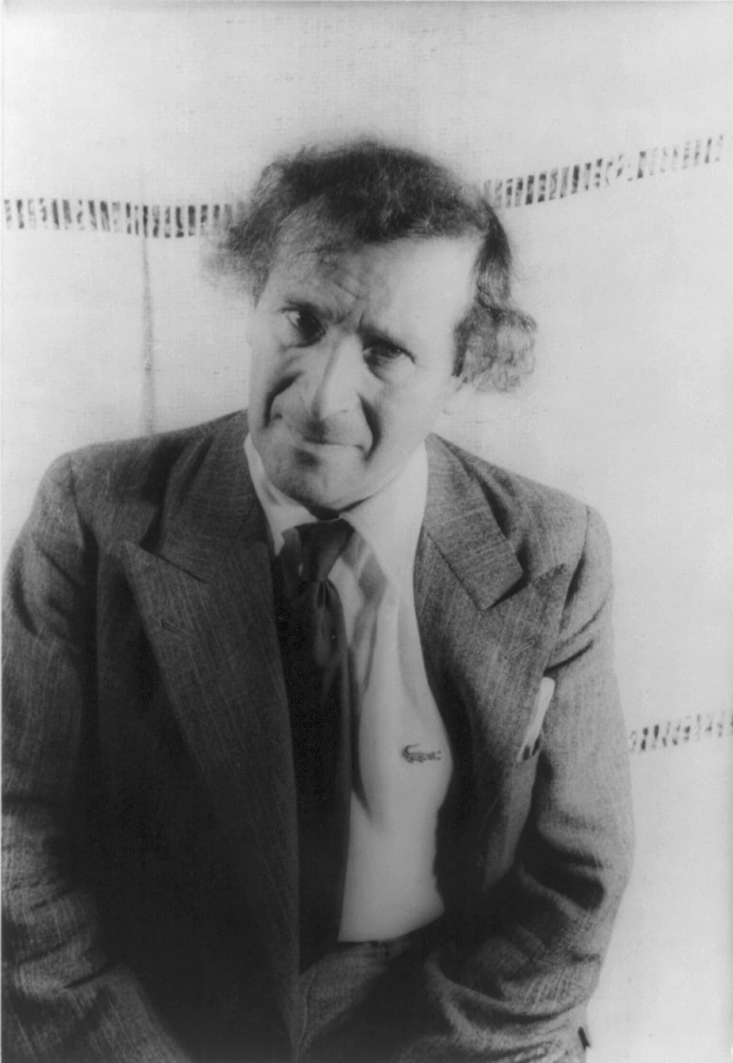 Marc Chagall at fifty-four, curly-haired, in a jacket and open collar, glancing to the side of the camera