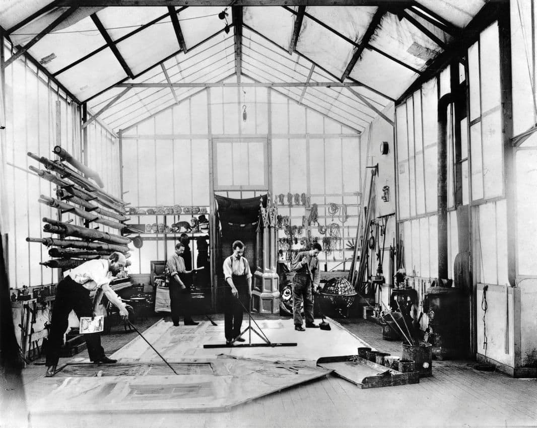Interior of Méliès's glass studio at Montreuil: glass roof and walls, scenery flats painted on the floor, prop racks and masks along the walls