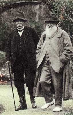 Georges Clemenceau with a cane and Claude Monet in a long coat, two old men walking side by side in the garden at Giverny
