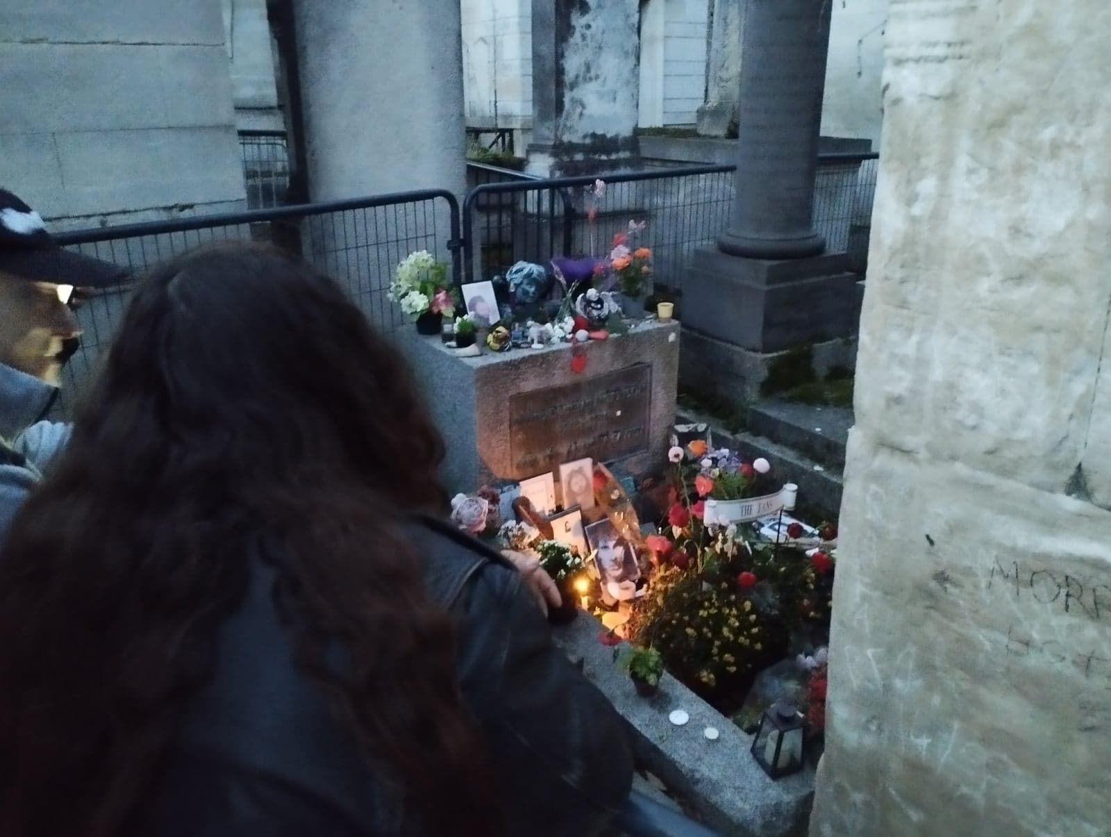 Visitors at Jim Morrison's fenced grave in division 6 of Père-Lachaise