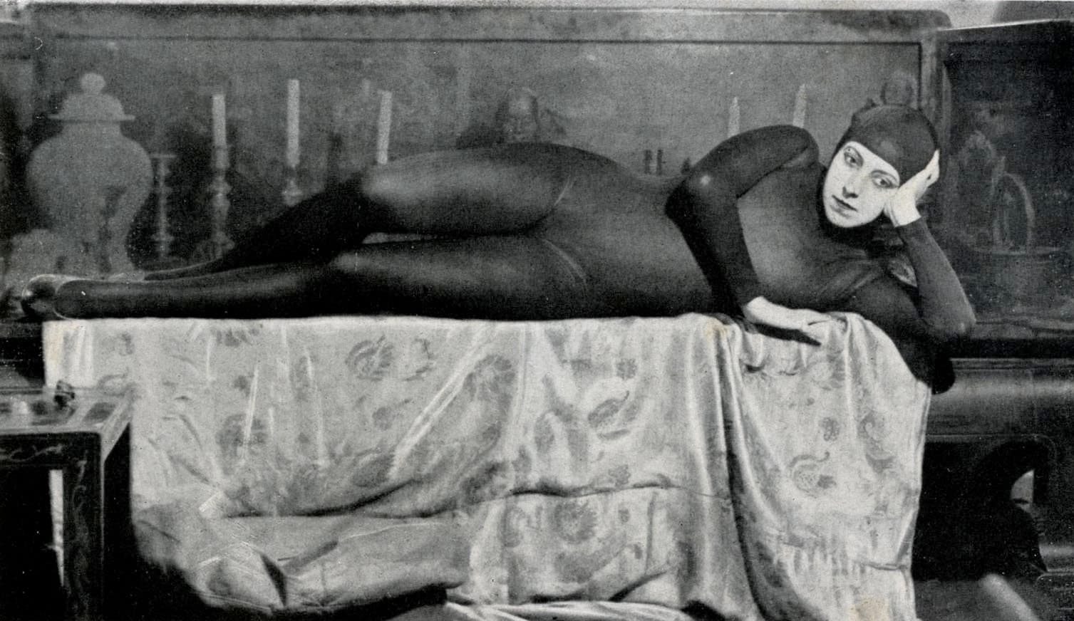 Musidora in Irma Vep's black hooded maillot, reclining with her chin on her hands