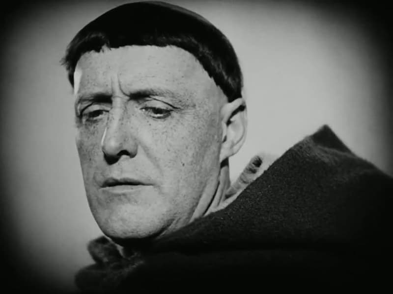 Antonin Artaud as the monk Jean Massieu, in close-up, eyes lowered under a dark fringe