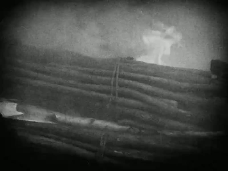 Smoke rises through the stacked logs of the pyre
