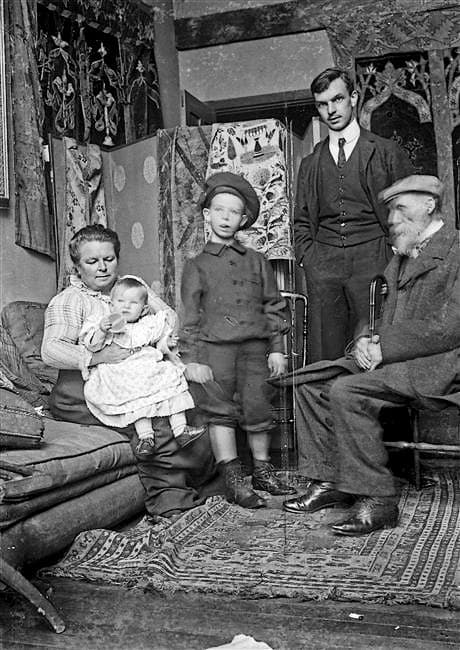 The Renoir family posed in an apartment: the elderly painter seated with his wife Aline and their three sons