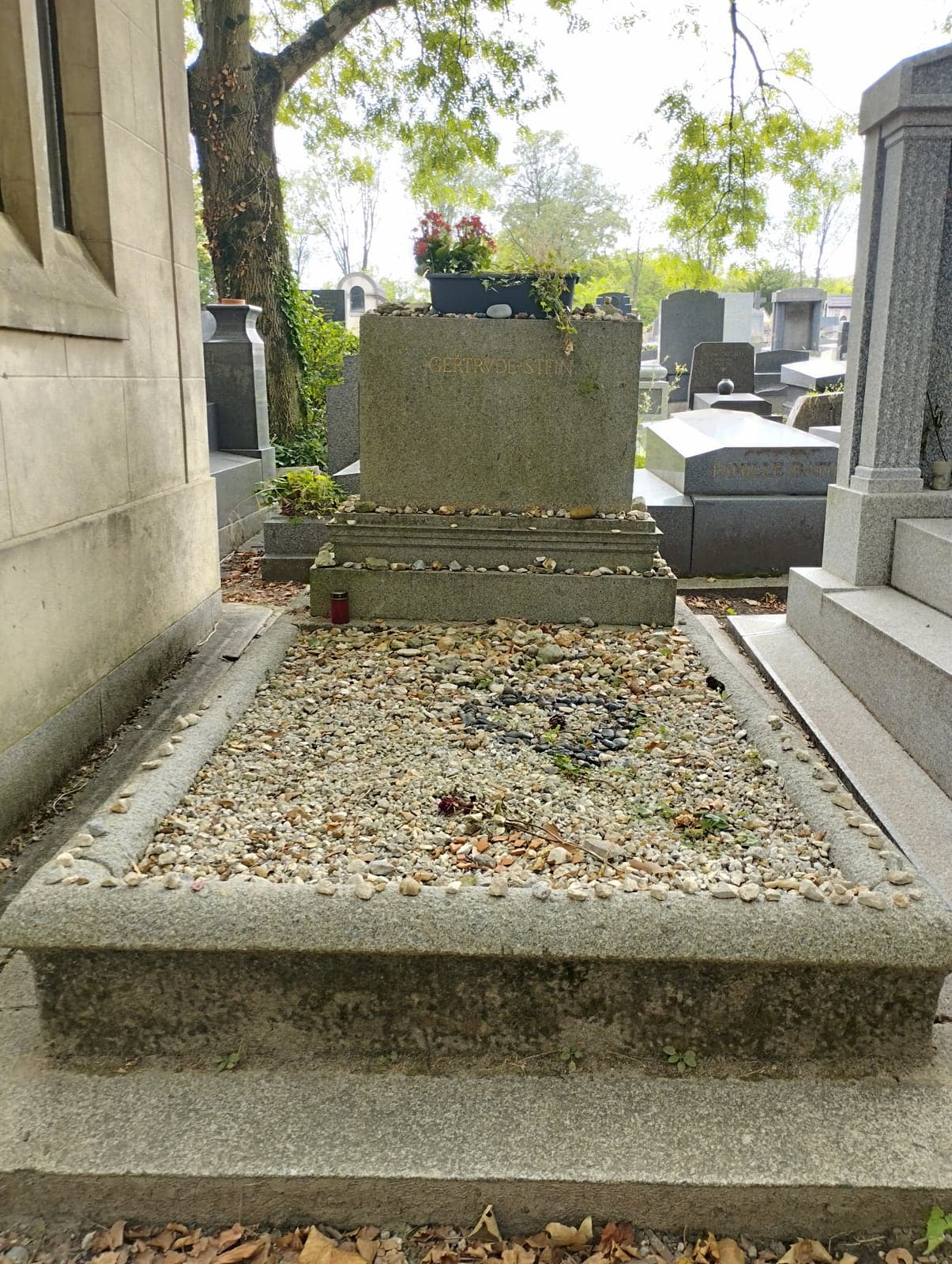 Gertrude Stein's headstone in division 94 of Père-Lachaise, its ledges lined with visitors' pebbles
