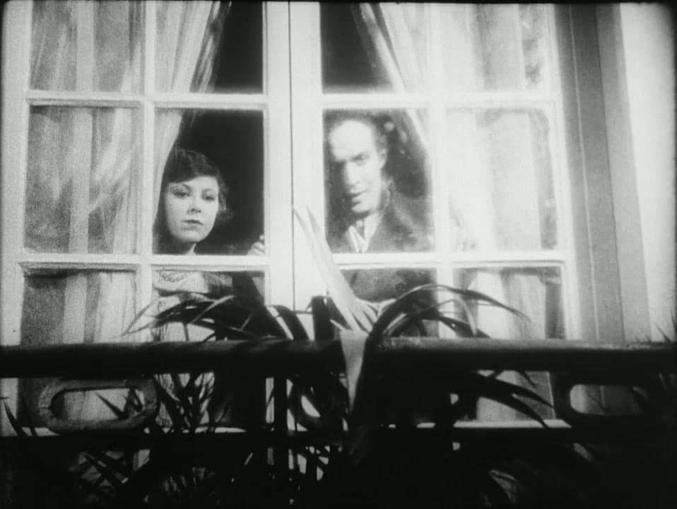 Simone Mareuil and Pierre Batcheff watch through a window with rapt faces in Un Chien Andalou