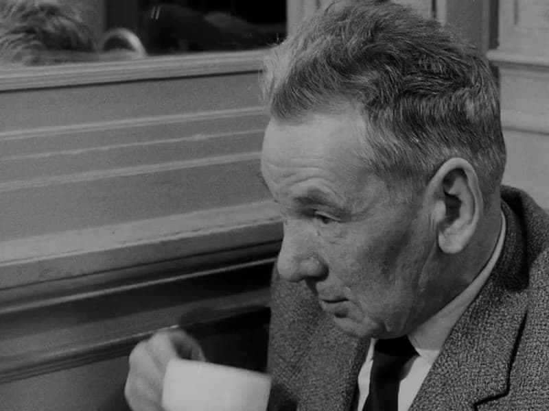 The philosopher Brice Parain, an older man, raising a cup at a café table