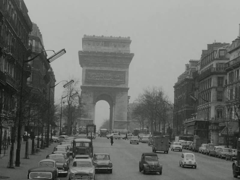 The Champs-Élysées and the Arc de Triomphe under a grey sky, traffic on the avenue